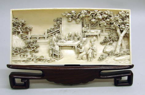 Chinese Carved Ivory Wristrest of Qing Dynasty: 19th C., deeply undercut with a continuous garden scene of scholars seated at a table with other figures surrounding. Finely carved from one solid piece of ivory. Nice patina on back. Includes