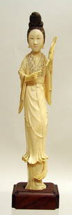 Chinese Carved Ivory Figure of Maiden: Late 19th C., standing figure holding a fan and a large coin, her hair wrapped high and wearing a flowing robe. Polychrome details. Nice patina and grain to ivory. Attached to wood base. 11"h x 2