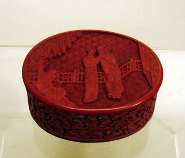 Small Chinese Carved Cinnabar Lacquer Box: 18th/19th C., in oval form carved in relief depicting a courtyard scene of two ladies on cover top, and wide floral band around sides. Box bottom/interior is black lacquer. Old wear and small chips