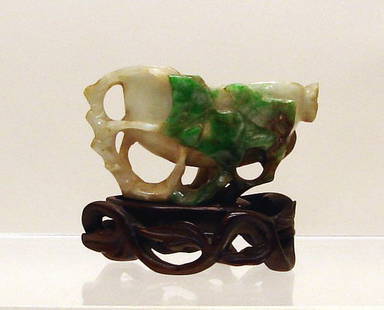 Chinese Carved Jade/Jadeite Cup: 19th C., on custom wood stand and carved as a natural style pedestal cup cradled by a leafy branch. The stone of grayish-celadon color with apple green and brown inclusions at leaves and branch. 2