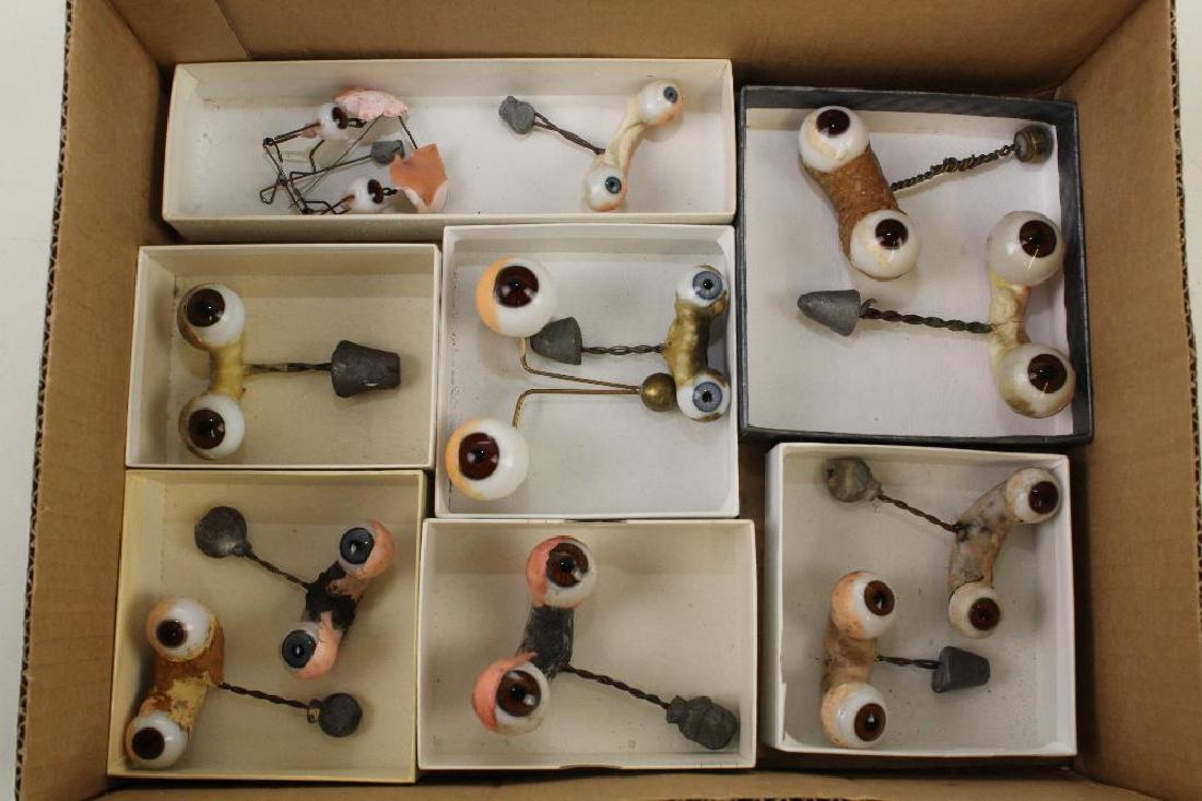 BODY PARTS - (12) PRS. OF ANTIQUE DOLLS EYES ON ROCKER: (9) Prs. brown, (3) prs. blue. (1) Pr. of flirty eyes. (1) Pr. Byelo eyes. The rest are mostly for larger dolls.
