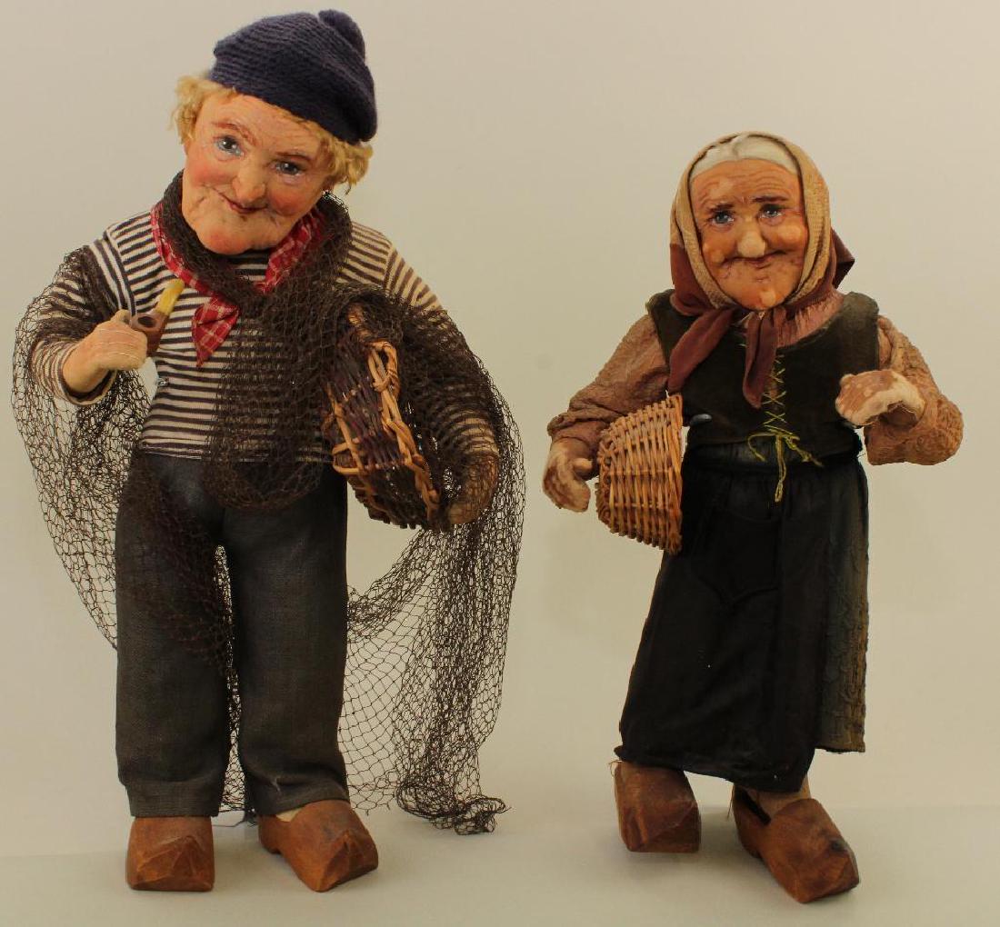 PAIR OF ALL ORIGINAL RAVCA FRENCH PEASANT DOLLS.: 15" Elderly woman carrying wicker basket. 17" Elderly fisherman smoking his pipe, carrying his wicker basket and net. Condition: age loss to female's face and hands. Age discoloration on both.