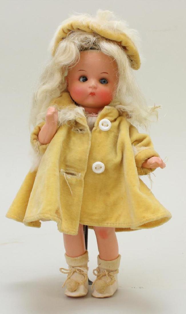 7" "JUST ME" REGISTERED GERMANY A.310/ll/0. ANTIQUE: Blue sleep eyes, closed mouth, replaced blonde mohair wig. 5 Pc. composition body. Dressed in 1950's tagged Ginger dress and velveteen coat/hat. Original oilcloth shoes, socks. Stand. Condition: nothi