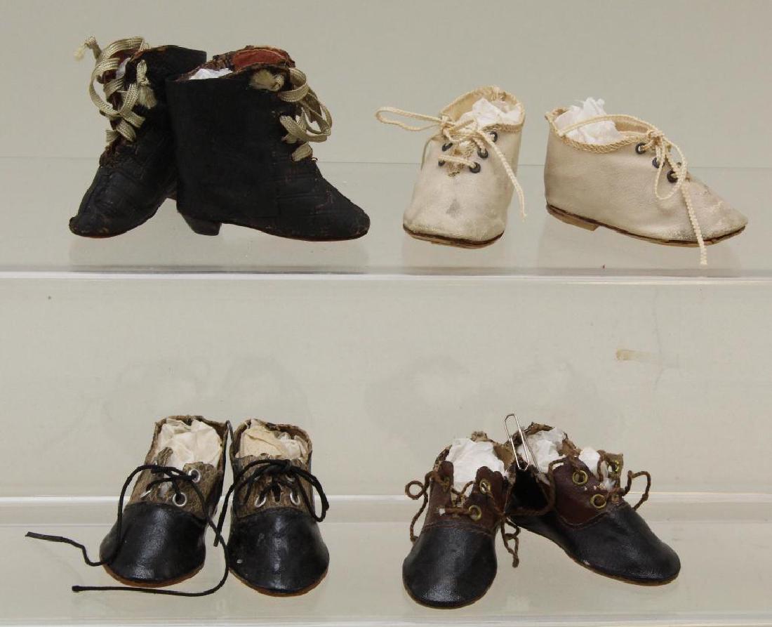 LOT OF ANTIQUE DOLL SHOES.: (4) Pairs. 2 3/4" Black oilcloth and faux snake "5" Made in Germany. 2 3/4" Ivory oilcloth lace up "6". 2 3/4" Black/brown oilcloth "5" Made in Germany". 2 1/2" Embossed black leather fashion boots wi