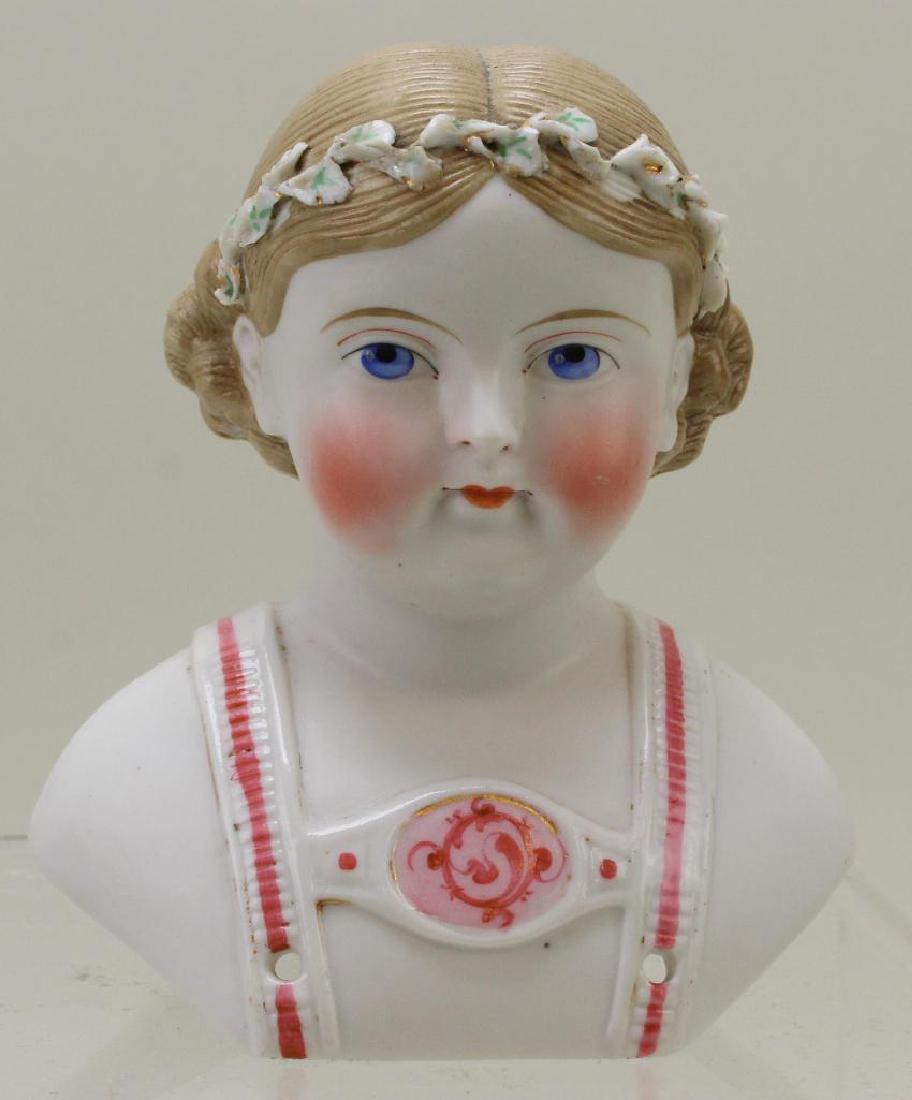 4 1/2" UNMARKED APPROX. 1875 FANCY PARIAN SHOULDER: Painted blue eyes. Blonde centerpart hair with curls on back. Modelled flowers in hair. Modelled and decorated bodice. Condition: some loss to flowers in hair.