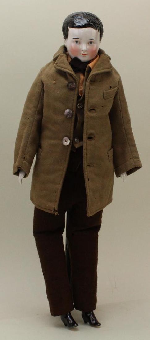 20 1/2" UNMARKED 1850's-1860's CHINA SHOULDER HEAD: Painted blue eyes. Short black hair. Nice cheek coloring. Cloth body with china lower arms, legs with molded heeled black boots. Dressed in vintage clothing : olive wool coat and vest. Brown wool knit