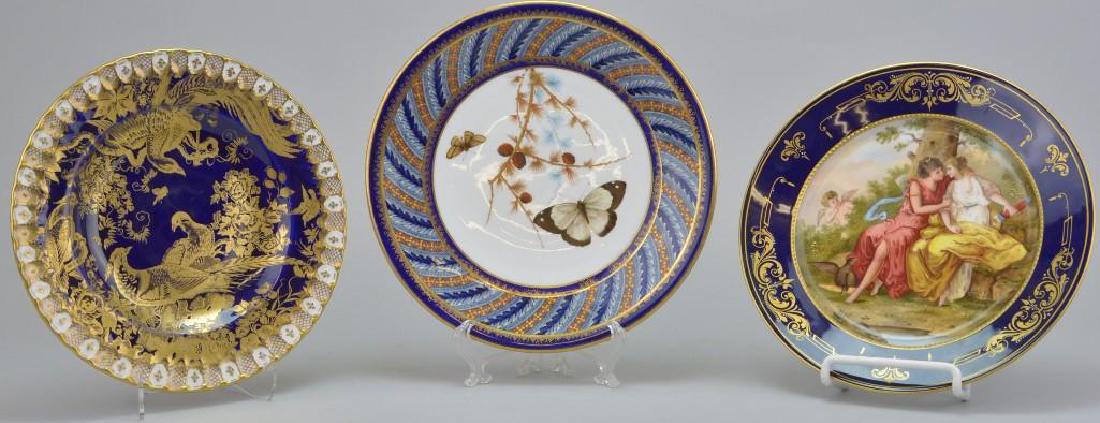 Cobalt Blue Plate Grouping: Royal Crown Derby with birds of paradise, 8.25"round; Royal Vienna genre scene, 8.75"round; and Royal Worcester Butterfly plate with green mark, 9"round
