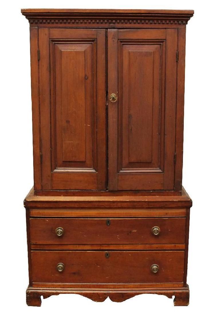 Linen Press: Pine with a dentil molded cornice, two doors over two drawers, shaped feet. 69”h x 37.25”w x 20.5”d