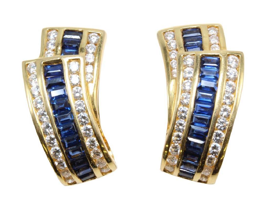 18K Yellow Gold Earrings with Blue Sapphires and: 1 x 1/2". Omega back pierced, resistance needs adjustment. Each earring features (14) 3 X 2.5mm emerald cut channel-set blue Sapphires and (29) 2.0-2.3mm round brilliant cut channel-set Diamonds, app