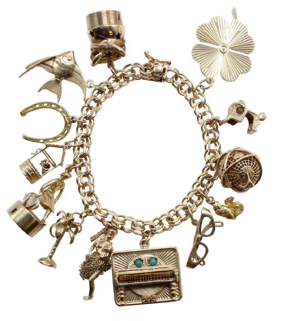 14K Yellow Gold Charm Bracelet with Charms: 7" long. 6.8mm wide double link style with box clasp and safety catch. Charms soldered to bracelet include: Crab on top of battery operated base with Star cut-outs, Fish, Horseshoe, Wishing Well, Lad