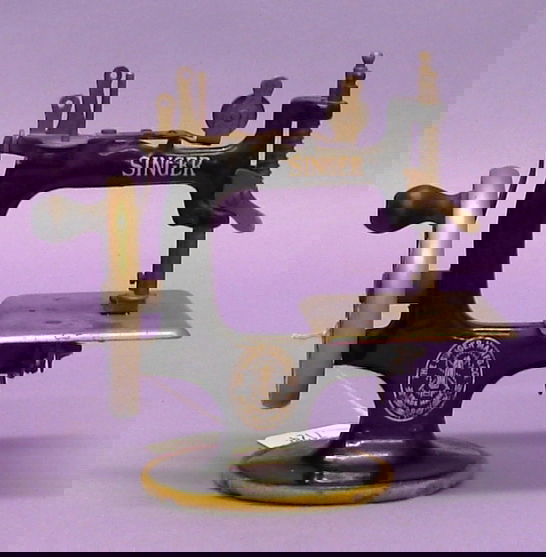 Singer toy sewing machine.: Singer toy sewing machine. Complete in all original. Very attractive. Has some discoloration along the nickel plated metal. Has a few paint chips. C-6 to 7 condition. 7 1/2".