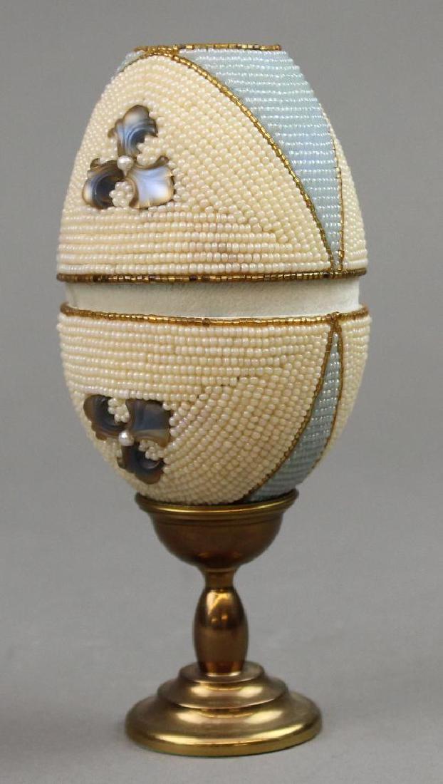Audrey Barna Kaleidoscope: Paper mache egg with blue and white pearl decoration with stand. 4". Audrey Barna