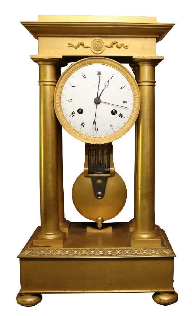 Mantel clock: French, Empire, circa 1810 Fire gilded bronze 20 1/2" H x 12" W x 7" D French Empire Portico bronze ormolu mantel clock, four columns, gilt bronze case, porcelain face.and Roman numerals, four hands o