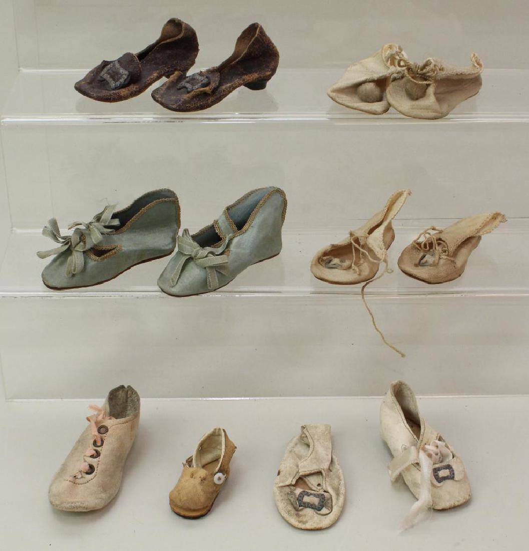 LOT OF ANTIQUE DOLL SHOES.: (3) Prs. of cloth shoes, (1) pr. of leather. Some leather singles. 3" - 3 1/4". Condition: age loss, discoloration. This lot is being sold AS IS.