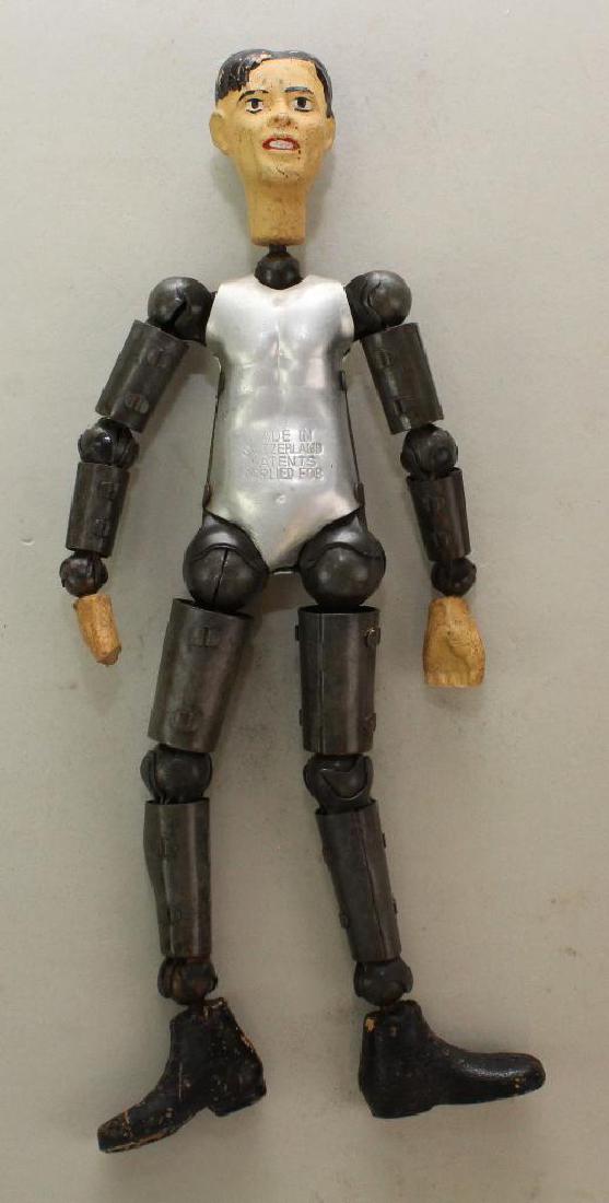 TOYS: 8" SWISS BUCHERER CHARACTER.: Composition head, hands and large feet. All metal body stamped: Made in Switzerland Patents Applied For. No clothing. Condition: age loss to both hands. Paint appears to be original. This lot is being