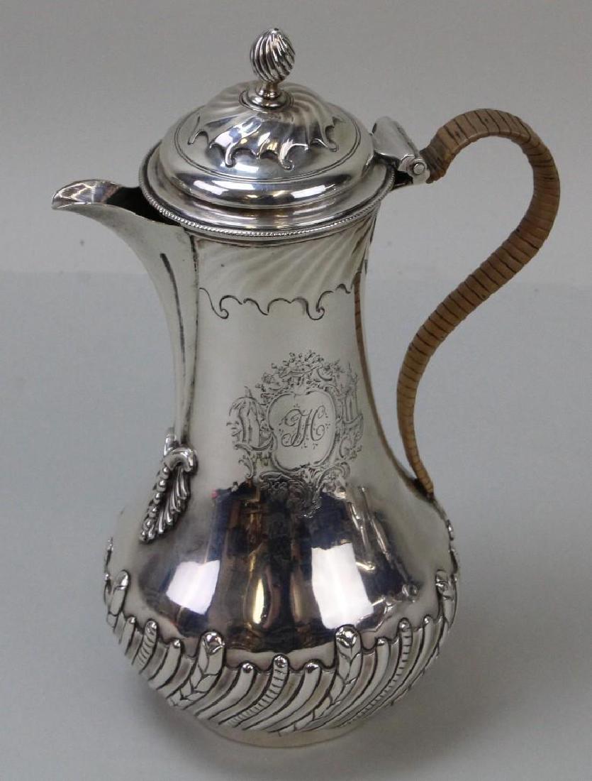 Georgian Sterling Coffee Pot: C. 1762. Unknown maker, dated 1762 London. Finely decorated lid, neck and base with hand chased cartouche bearing an "H" monogram. Cane wrapped handle and flame finial. 9"H x 6"W. 13.14ozt