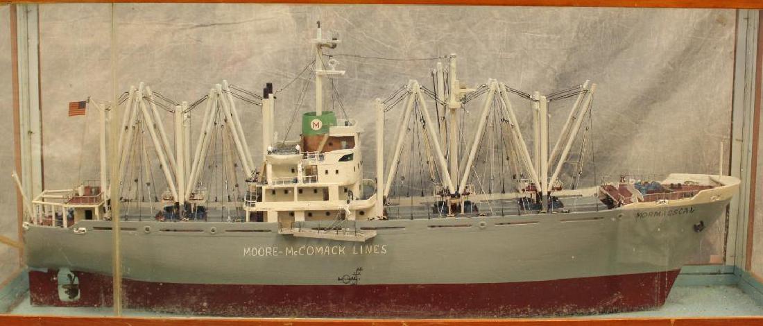 Moore-McCormack Lines Model Ship: Wood ship model of the "SS Mormacscan", a late 20th century U.S. cargo freighter measures 21" (H) x 50" (L) x 7" (W). Ship housed in glass case measuring 29.5" x 56.5" x 14.5". The SS Mormacscan was b