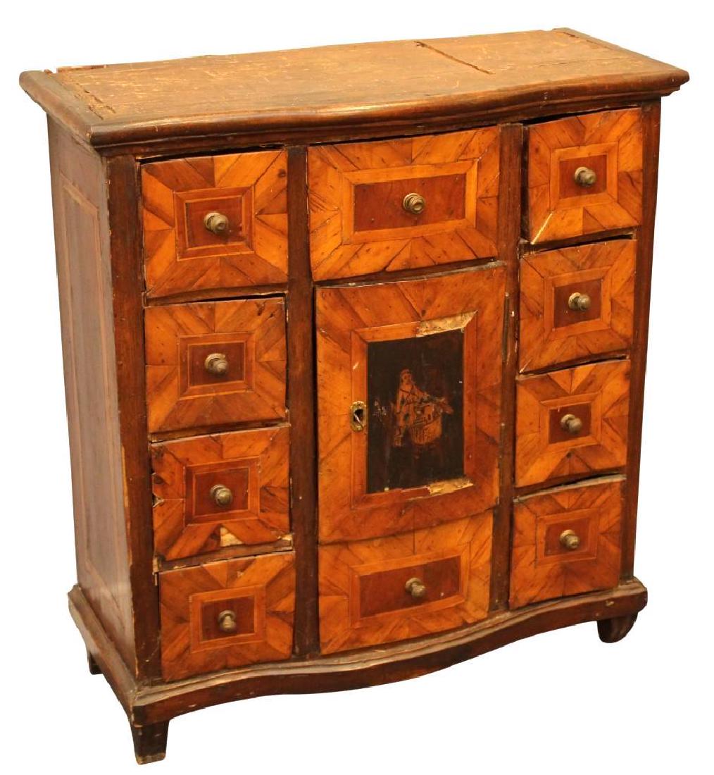 Apothecary Cabinet: Multi drawer cabinet with banded wood, marquetry center door with image of boy and sword. Shows wear. Measures 32"H x 29.5"W x 12.5"D.