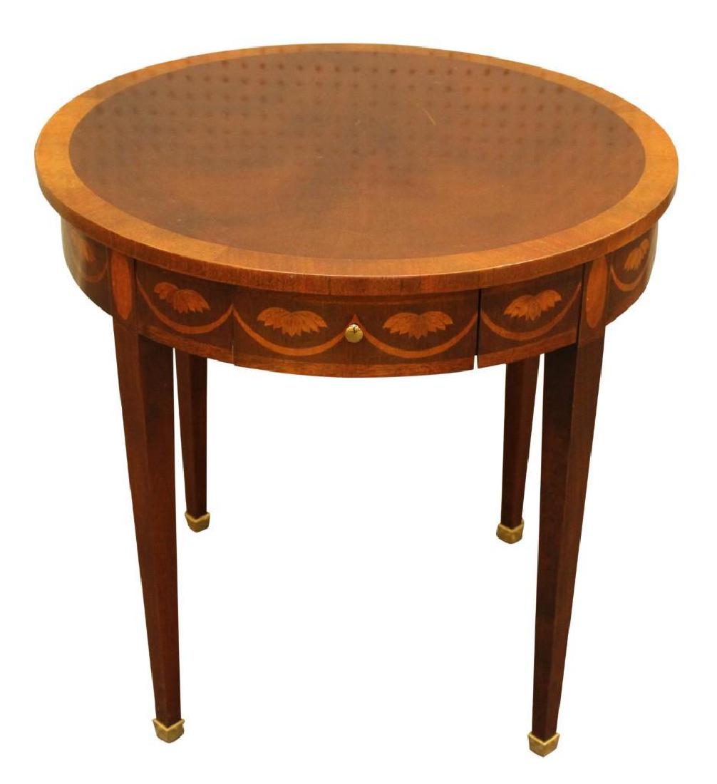 Baker Accent Table: Drum table with banded inlay top and marquetry frieze, with two drawers and two pull out shelves. Tapered legs over brass capped feet. Measures 25"H x 25.2"diameter.