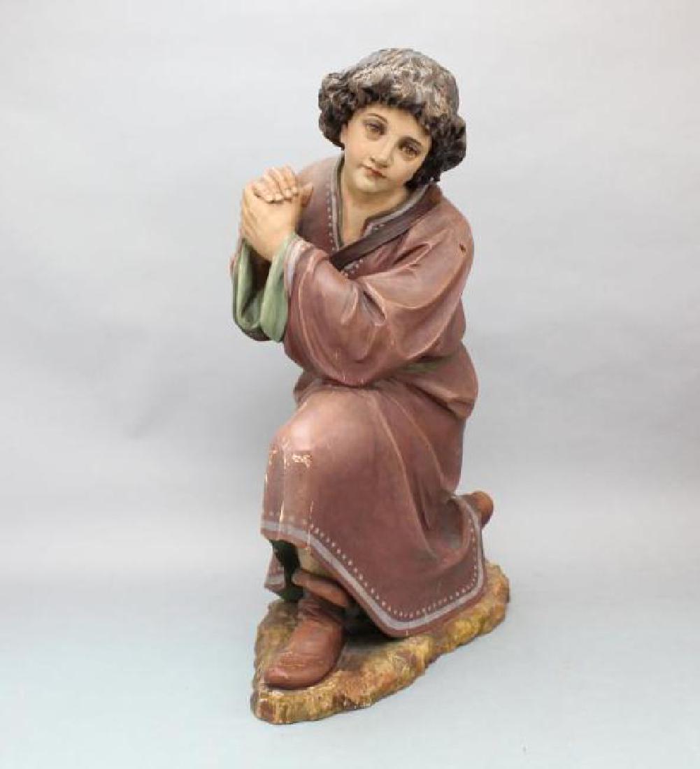 Kneeling Statue: Painted wood carved statue of a kneeling shepherd boy, most likely part of a larger nativity scene. Measures 9"w x 22"d x 28"h.