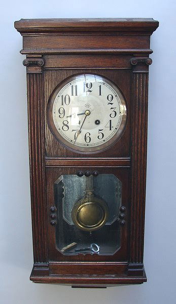 Wall Regulator Clock: 8 day, time and strike, oak case with lower beveled door glass, 31" H x 13" W x 6" D.