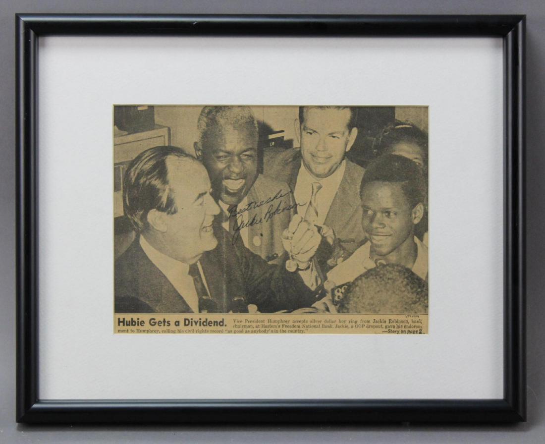 Jackie Robinson Autograph: Autograph of baseball great Jackie Robinson (1919–1972) the first African American to play in Major League Baseball. Autographed newspaper image of Robinson with Hubert Humphrey regarding civil righ
