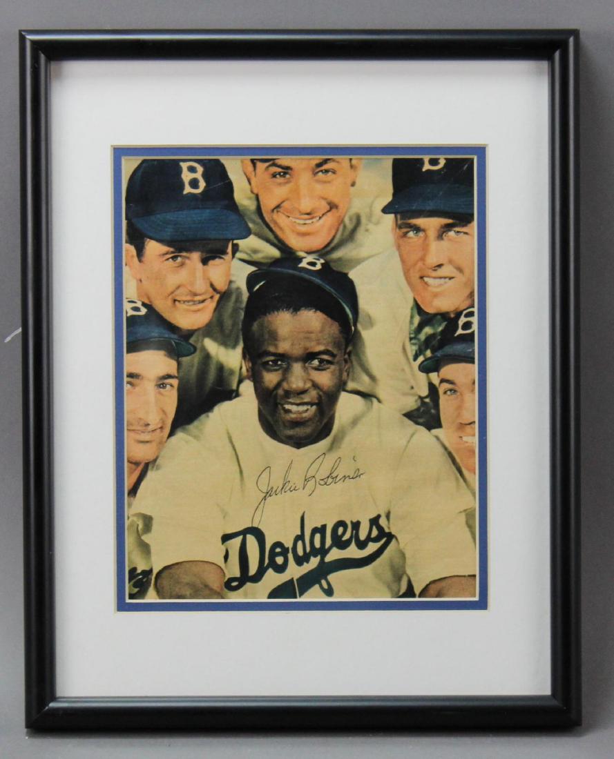 Jackie Robinson Autograph: Autograph of baseball great Jackie Robinson (1919–1972) the first African American to play in Major League Baseball. Autographed color newspaper/magazine image of Robinson surrounded by other Brookl