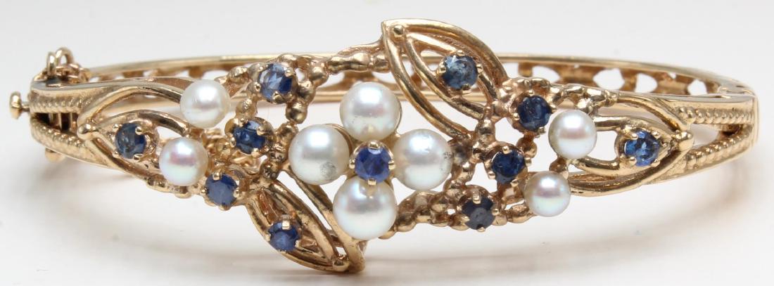 Bracelet. Sapphire and Pearl. 14K Yellow Gold Hinged: 2 1/2 X 1 3/4" I.D. Pressure tongue clasp with safety catch and chain. Features (4) 5.0mm round Pearls, (4) 3.5 - 4.0mm round Pearls and (11) 2.5 - 3.0mm round faceted Sapphires. 20.7gtw.
