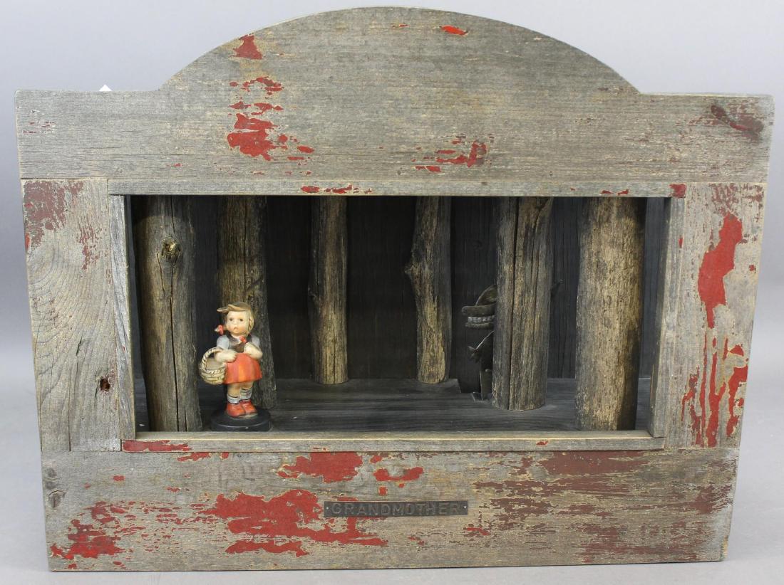 Tomas Savrda Kinetic Sculpture: Wood sculpture entitled "Grandmother" with Little Red Riding Hood figure and metal wolf pendulum that moves when initiated. Measures 21.5"w x 7"d x 17"h.