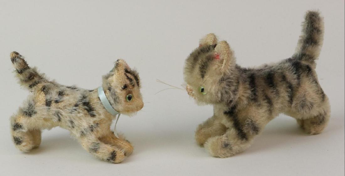PAIR OF UNMARKED ANTIQUE MOHAIR CATS.: STEIFF? Both are white mohair with dark gray airbrushed stripes, green glass eyes, pink embroidered noses. 4 1/2", 6". Condition: age wear, loss on mohair. This lot is being sold AS IS.
