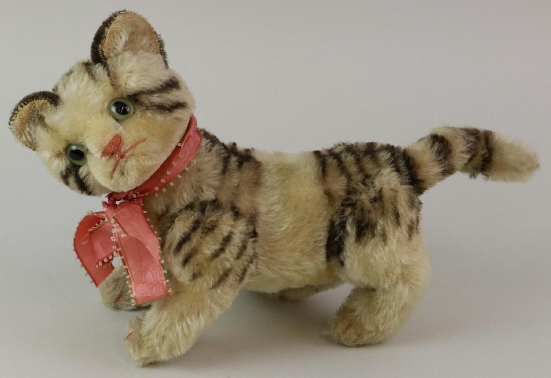 12" L. UNMARKED VINTAGE STEIFF MOHAIR CAT.: Ivory mohair with black airbrushed highlights. Fully jointed with swivel head. Green glass eyes. Replaced silk neck ribbon. Condition: some age wear/discoloration on mohair.