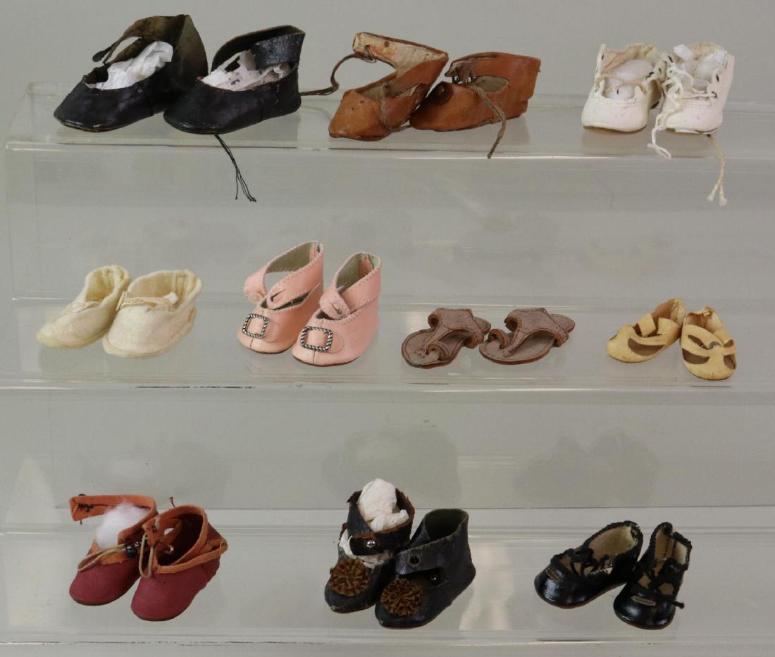 LOT OF DOLL ACCESSORIES: SHOES.: Lot of (10) prs. of various cloth, oilcloth, antique leather, reproduction leather. (1) Pr. Is marked Germany. (1) Reproduction pair (pink) is marked G.B. Shoes are 1 1/2" - 2 1/2". Condition: this lo