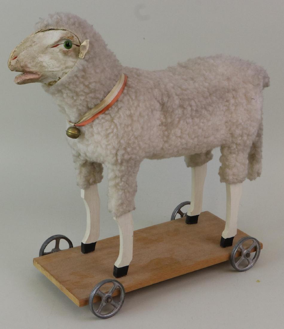 LOT OF HOLIDAY/NOVELTY ITEMS.: 13" T. Unmarked Sheep on platform. Head is papier mache with green glass eyes, only (1) leather ear. Body is covered with wooly type fabric. Wooden legs. Sheep stands on wooden platform 5" x 11 1/2". 