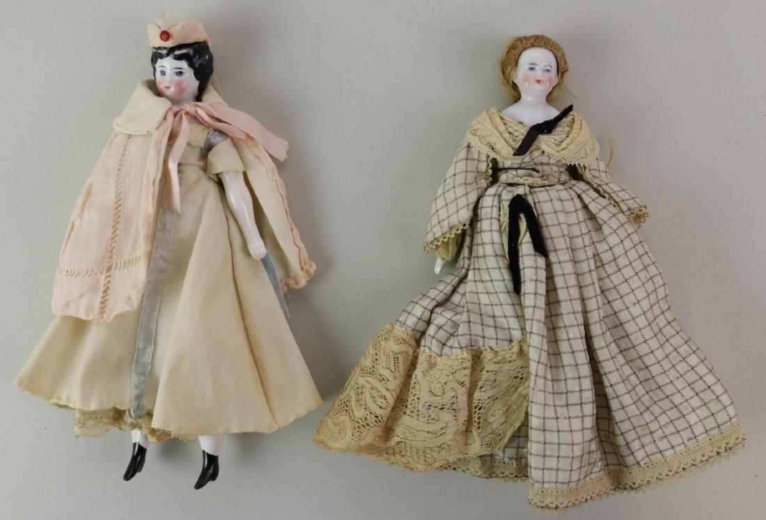 LOT OF CHINA/PARIAN DOLL(S).: Pair of antique china head dolls. 8 1/2" Lowbrow with black hair, blue eyes. 8" Bald china head doll with honey blonde human hair wig, blue eyes. Both are wearing clothing made from antique fabrics/tr