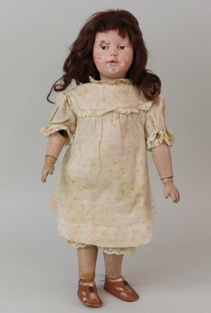 SCHOENHUT DOLL.: 14" Model 308 Schoenhut doll with incised mark on back of torso. Brown integlio eyes, replaced brown mohair wig. Redressed in cotton clothing, brown leather sandals. Condition: face badly chipped. No 