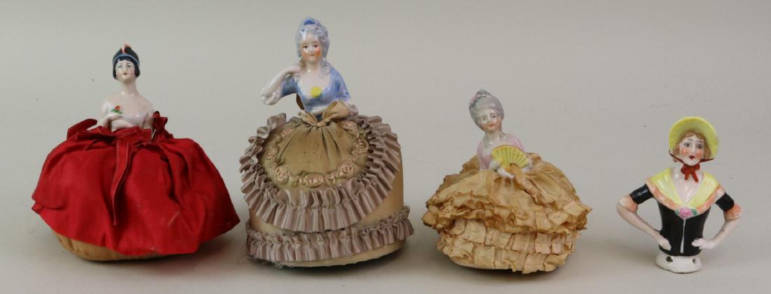 LOT OF HALF DOLL(S).: Lot of (4) china half dolls, (3) mounted on pin cushions. All of them have painted, molded features and hair. 4 1/2" With gray decorated hair is holding a fan. Japan. 9" With gray decorated hair. Japa