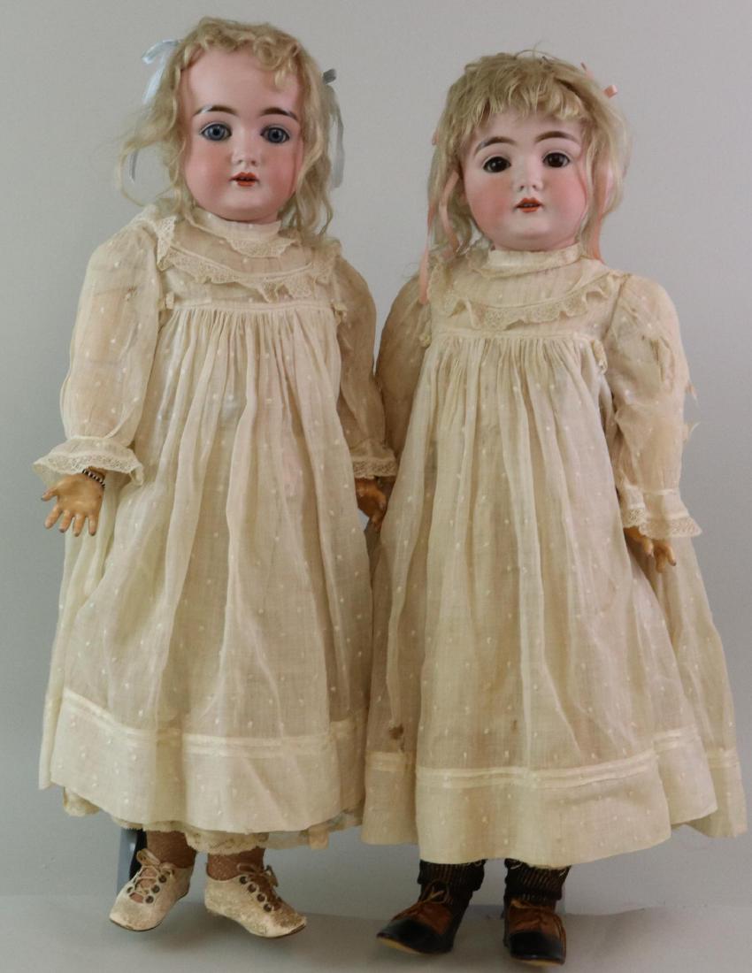 PAIR OF ANTIQUE BISQUE HEAD GERMAN DOLLS.: Pair of 25" K Made in Germany 14 146 twin dolls. (1) Has blue sleep eyes, the other brown. Both have open mouths, blonde mohair wigs, plaster pates. Papier mache ball jointed bodies. Both are dressed
