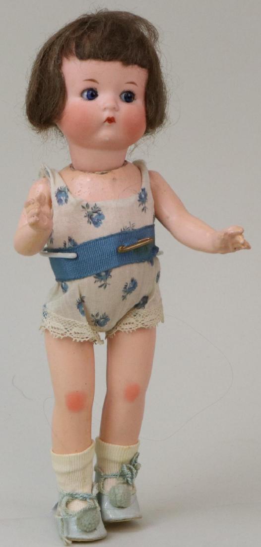 ANTIQUE BISQUE HEAD DOLL(S), 12" AND UNDER.: 9" JUST ME" Registered Germany A.310/7/0.M with blue side glance sleep eyes, closed mouth, brown mohair wig. 5 Pc. papier mache body. Dressed in antique floral teddy. Blue cloth shoes with poms, socks