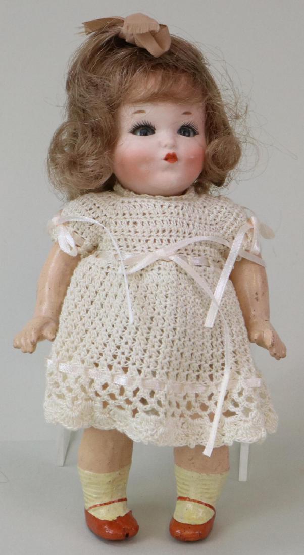 ANTIQUE BISQUE HEAD GERMAN DOLL.: 7 1/4" 11173 4/0 (Heubach) Germany "Tiss Me" character doll with blue sleep eyes, closed mouth, dimples, brown French human hair wig. 5 Pc. papier mache toddler body with painted tan shoes. Dressed in