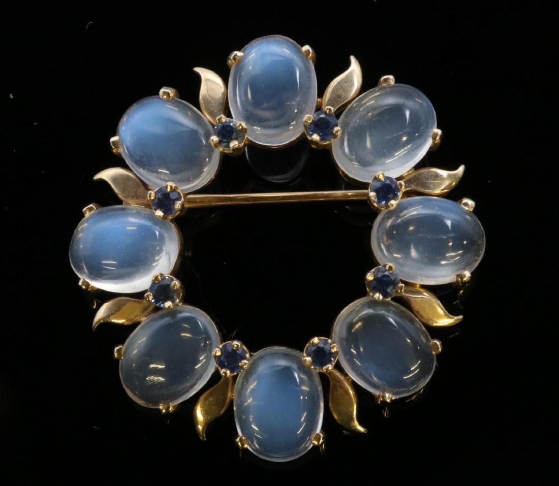 Brooch Pin. Moonstone and Blue Sapphire. 14KY Gold: 1 1/4" diameter. Features (8) 9 X 7mm oval Moonstone cabochons and (8) 2.5mm round Sapphires. 7.6gtw.