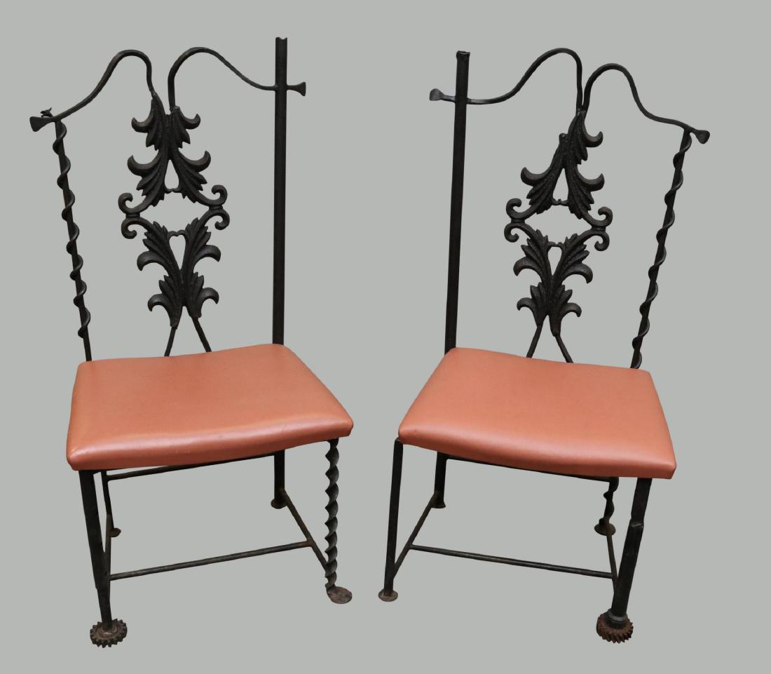 (2) J.W. Zan Reclaimed Wrought Iron Chairs: Made from reclaimed wrought iron welded materials. Each chair has a twisted corkscrew back rail with a foliate leaf splat, one leg each has a gear mechanism, and more. 45”h x 21”w x 16”d