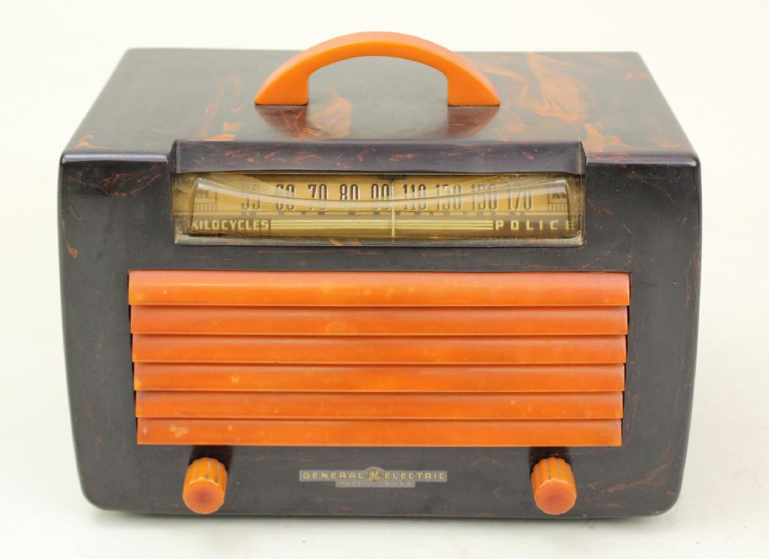 General Electric Catalin Radio: Model L570. Marbleized black with yellow insert grill and handle. Crack and chip on rear left facing. Dial plastic has warped inward. Made in 1941. Cord intact. Powers on.