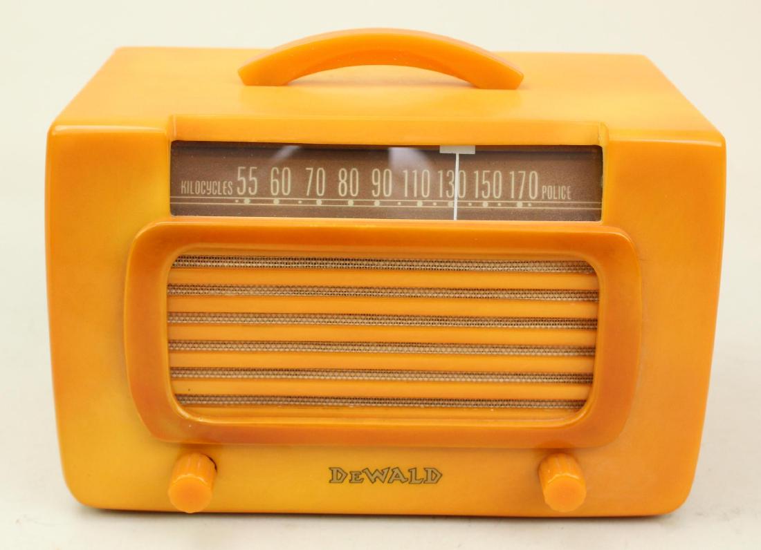 DeWald Catalin Radio: Model 561-2. Outline grill DeWald. Alabaster with red trim. c.1939. Body has been professionally restored and repaired on LH side facing. Cord intact. Dial lights when powered on.