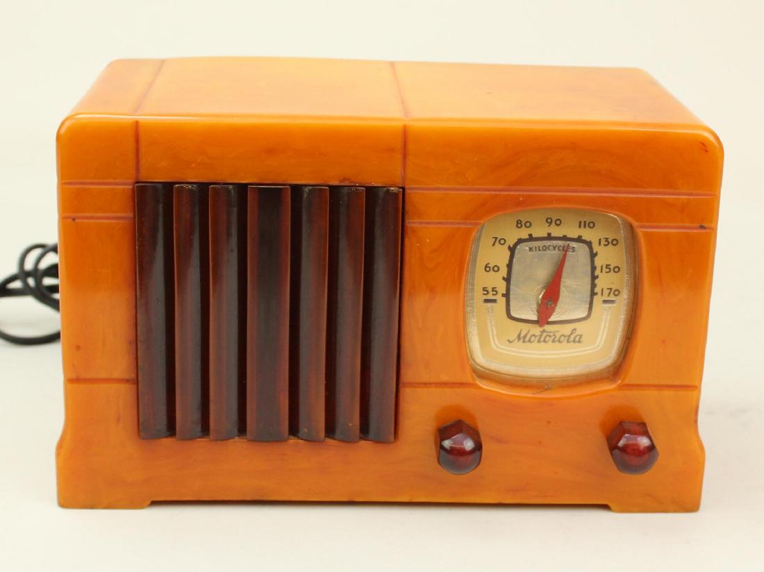 Motorola Catalin Radio: Model 52. Butterscotch with dark brown trim. Slight crack on right side. c.1939. Large repaired crack on RH side continuing to chassis mount. Cord intact. Powers on and dial lights.