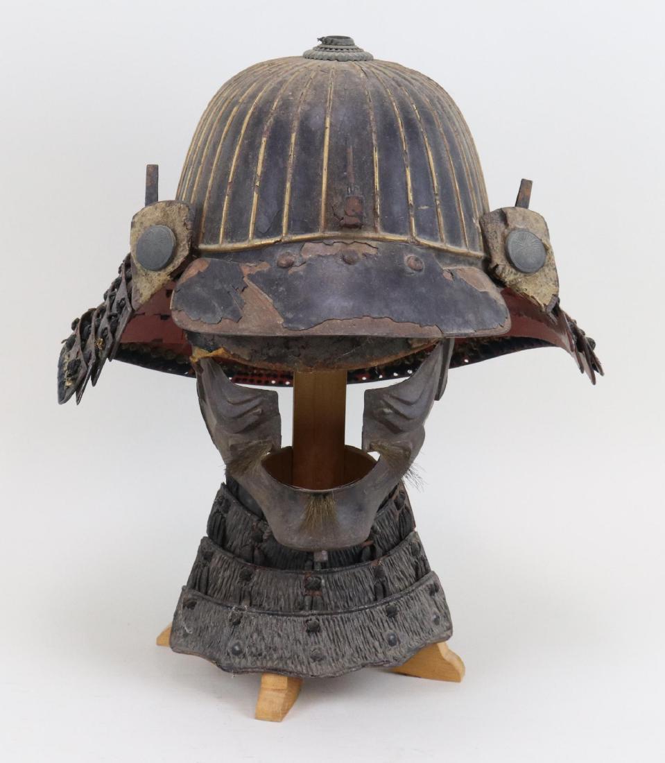 Japanese Armor From The Edo Period: Set of Japanese armor from the Edo period (1603-1868) consisting of helmet (kabuto) with 5-plate neck guard. Helmet measures 11" x 13". Set includes face guard (men yoroi) presenting facial features a