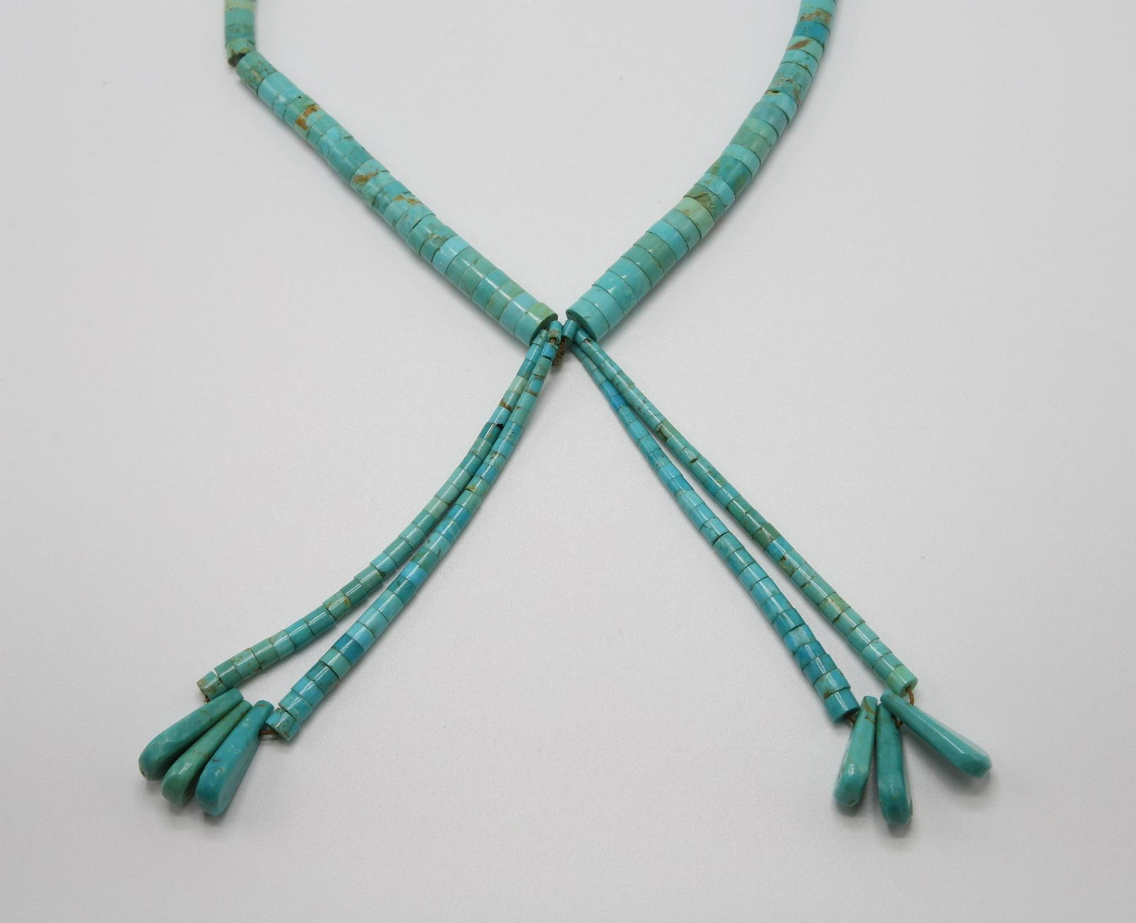 Sterling Silver on Turquoise Heishi Necklace: 23 1/3" long graduated heishi bead strand with (2) 4" long tassel dangles of heishi beads and carved faceted teardrops. 37.4gtw.
