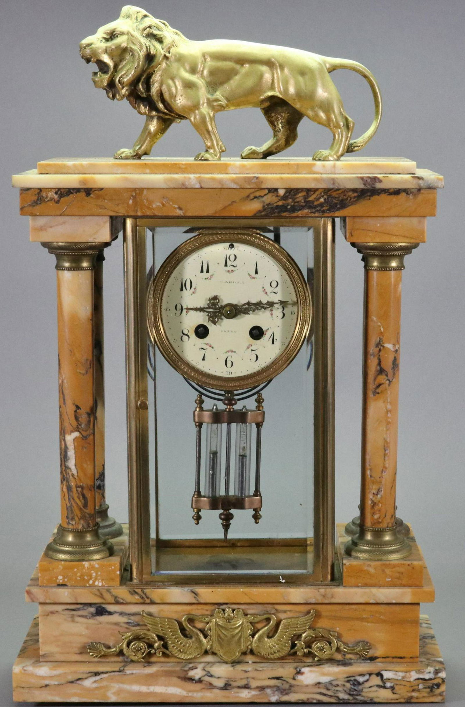 French Marble Mantel Clock: White enamel dial with Arabic numerals, mercury pendulum, four free standing columns and bronze lion on the top. 19.75"h x 11.75"w x 5"d