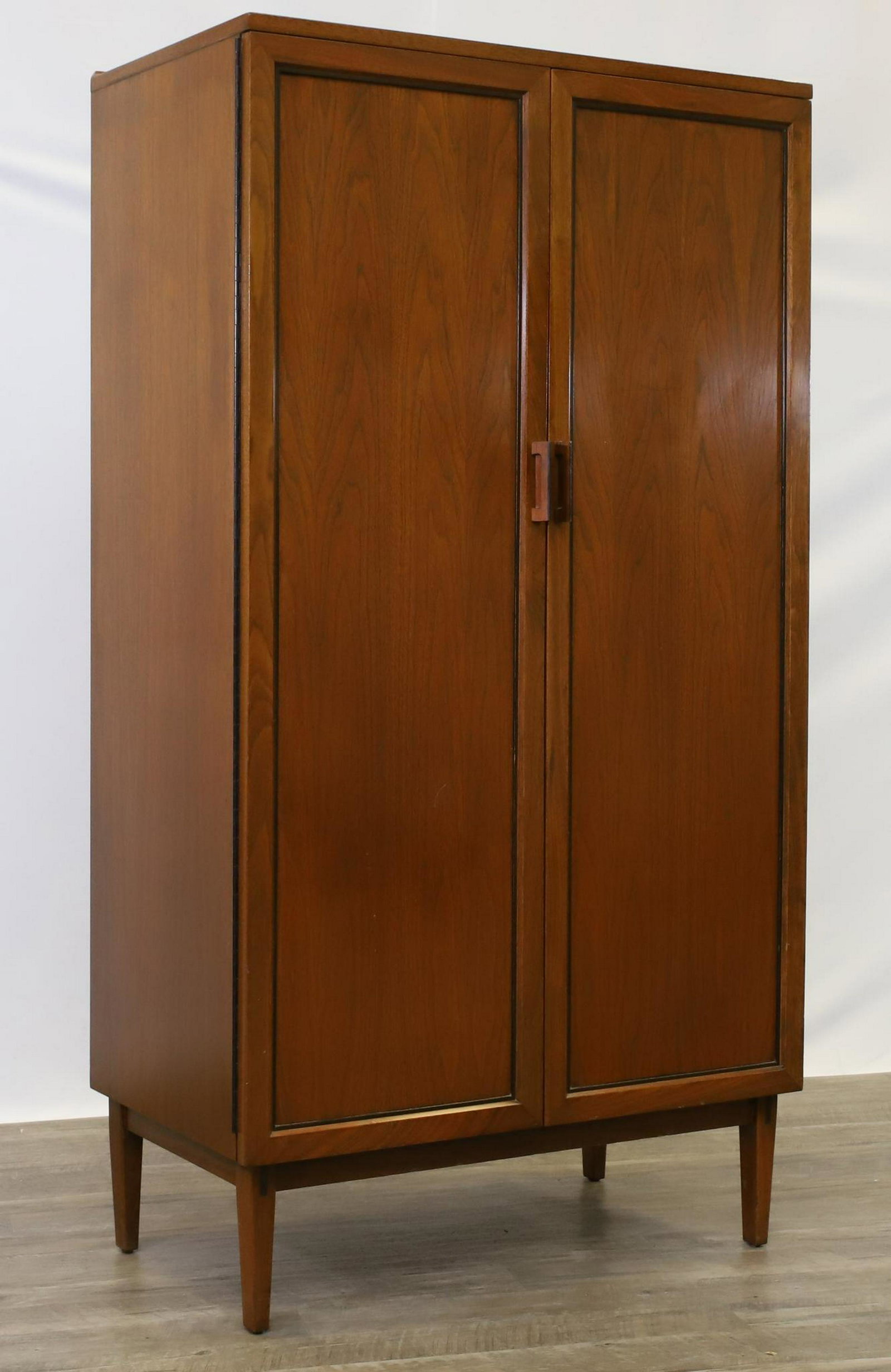 Attributed to Kipp Stewart for Directional by Calvin: Mid-century modern high chest. Walnut with two doors opening to ten graduated drawers on tapered legs. Label reads "Directional Calvin Furniture Co. Grand Rapids, Michigan". 59"h x 32"w x 19"d