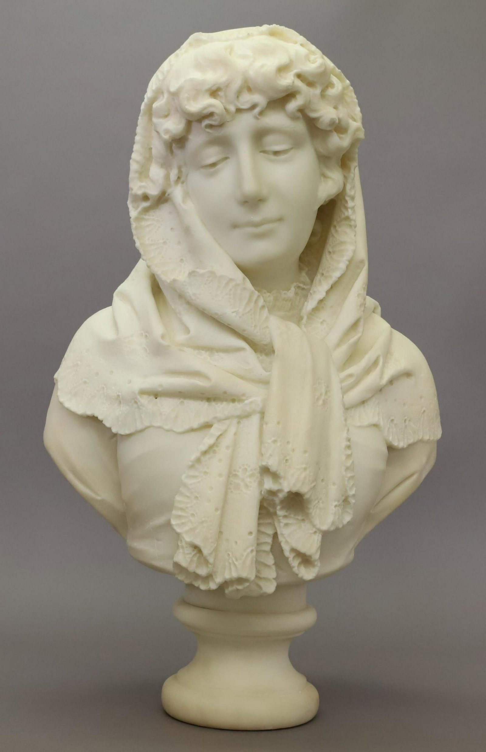 Alabaster Bust: Alabaster, bust of a woman with her head adorned with a lace scarf. Signature has been ablated en verso.