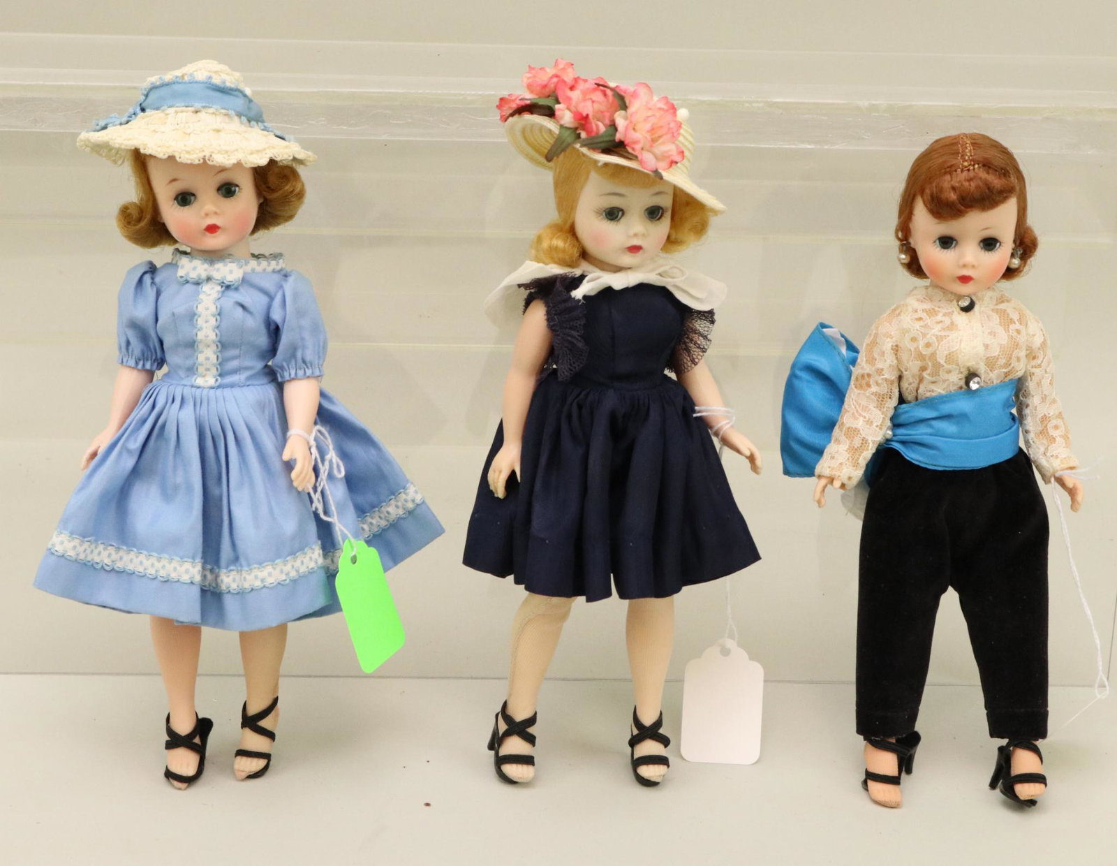 LOT OF 1950's - 1960's DOLL(S).: Lot of (3) Madame Alexander "Cissette" dolls dressed in late 1950's tagged outfits. Doll 1) with honey blonde flip is wearing a 1958 blue cotton sateen dress #810. Doll 2) with blonde flip is wearing 